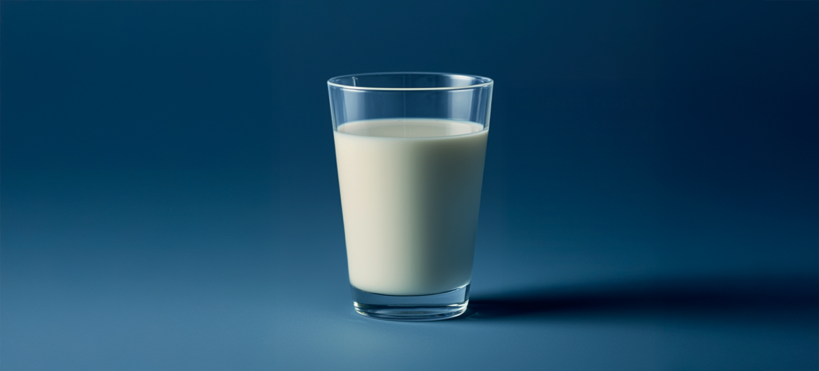 Bicchiere di latte su sfondo blu